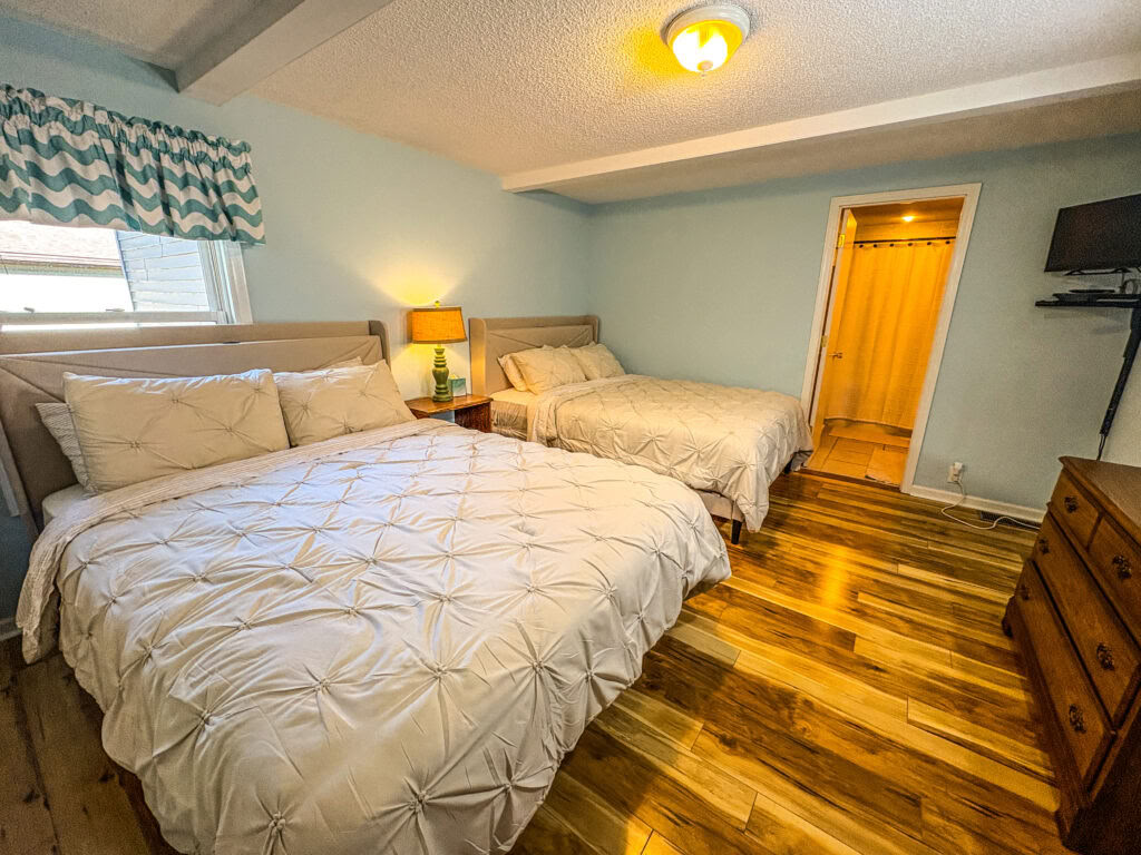 Ein Queensize-Bett in einem geteilten Zweibettzimmer mit gemeinsamem Badezimmer