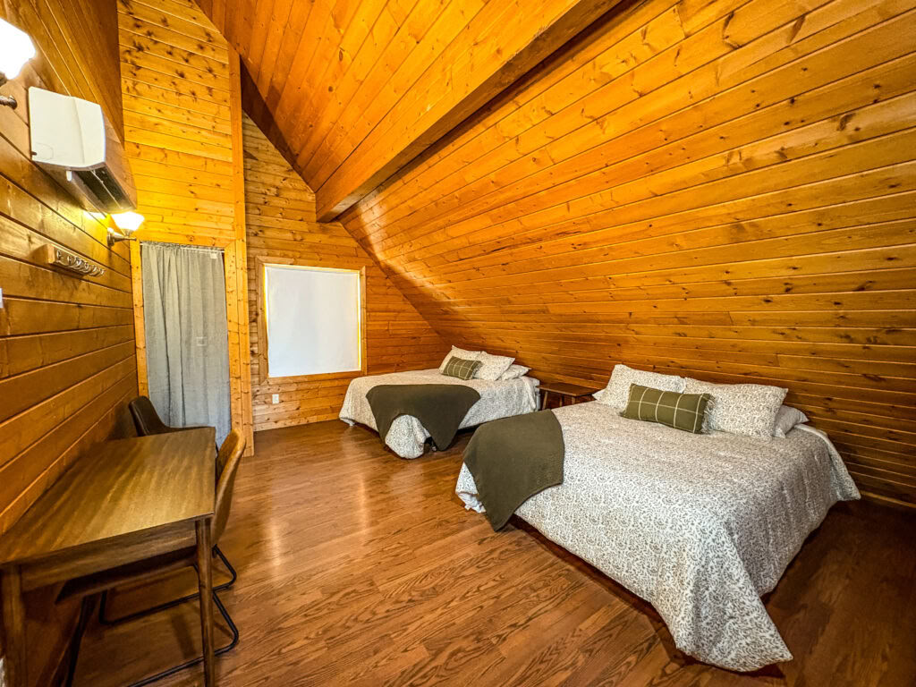 Ein Queen-Loft-Bett in einer geteilten Zwei-Queen-Kabinen-Loft mit Gemeinschaftsbädern